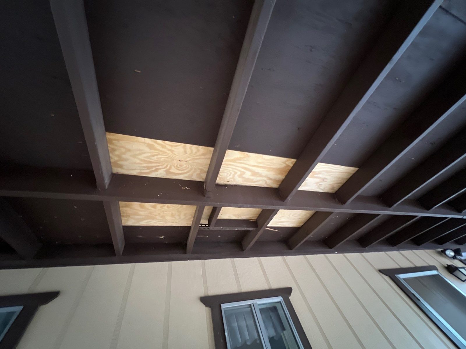 Storm-damaged soffit and decking seen from below